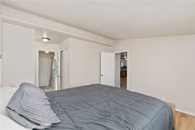 bedroom with wood-type flooring and vaulted ceiling