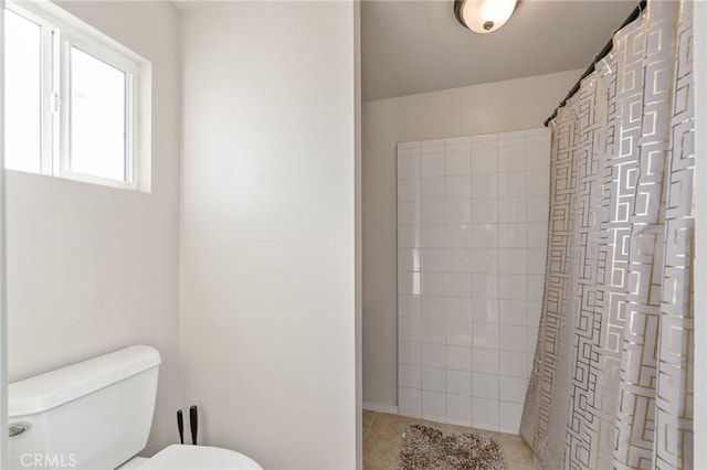 bathroom featuring toilet and curtained shower