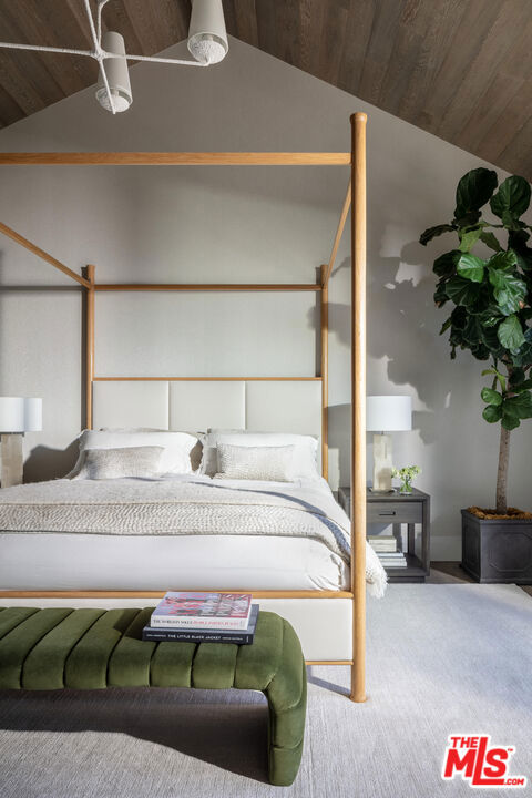 bedroom featuring wood ceiling, vaulted ceiling, and carpet