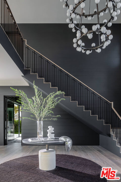 stairs featuring a towering ceiling and wood-type flooring