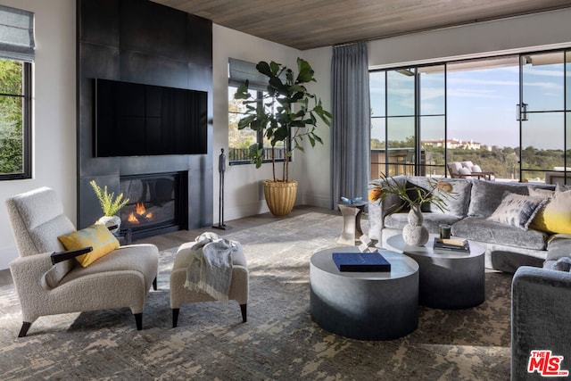 living room with a healthy amount of sunlight, wood ceiling, and a fireplace