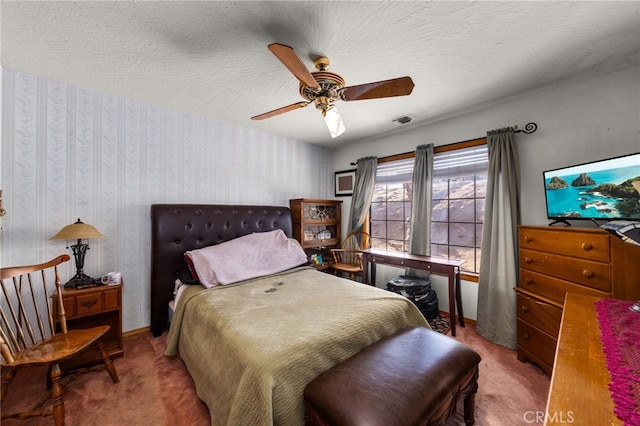 carpeted bedroom with ceiling fan and a textured ceiling