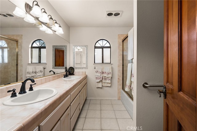 bathroom featuring tile patterned flooring, vanity, and enclosed tub / shower combo