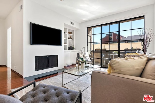 living room featuring hardwood / wood-style flooring and built in features