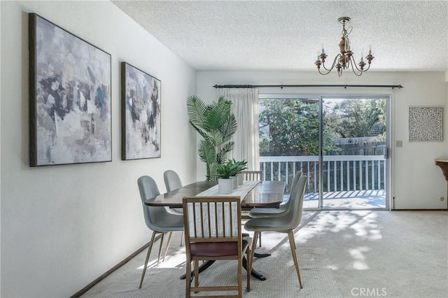 dining space with a textured ceiling, carpet, and a notable chandelier