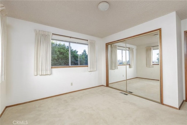 unfurnished bedroom with a closet, carpet floors, and a textured ceiling