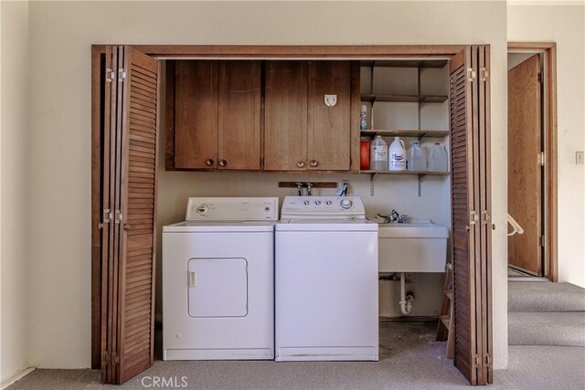 laundry area featuring washer and clothes dryer and cabinets