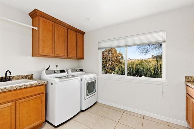 laundry area featuring cabinets, separate washer and dryer, sink, and light tile patterned floors