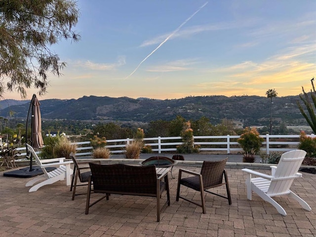 patio terrace at dusk with a mountain view and a fire pit