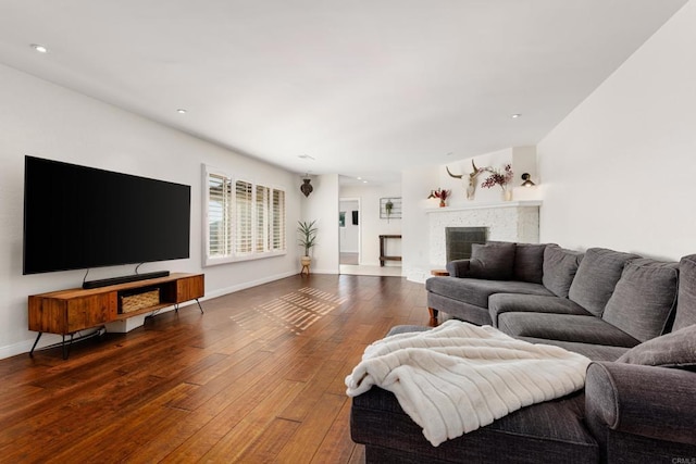 living room with dark wood-type flooring and a fireplace