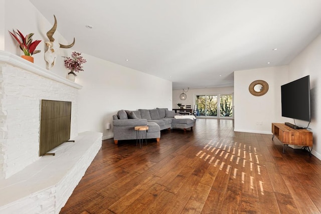 living room with a fireplace and wood-type flooring