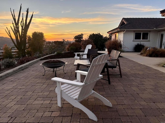 patio terrace at dusk featuring a fire pit