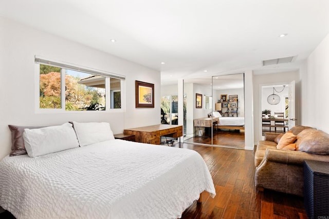 bedroom with dark wood-type flooring, a closet, and multiple windows