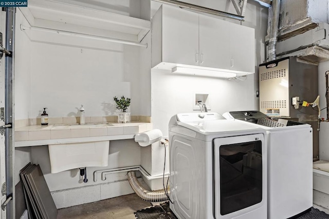 laundry area featuring sink, cabinets, and washing machine and clothes dryer