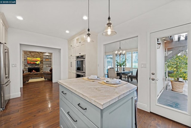 kitchen with decorative light fixtures, a kitchen island, and white cabinets