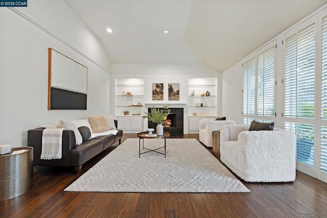 living room with dark wood-type flooring, vaulted ceiling, and built in shelves