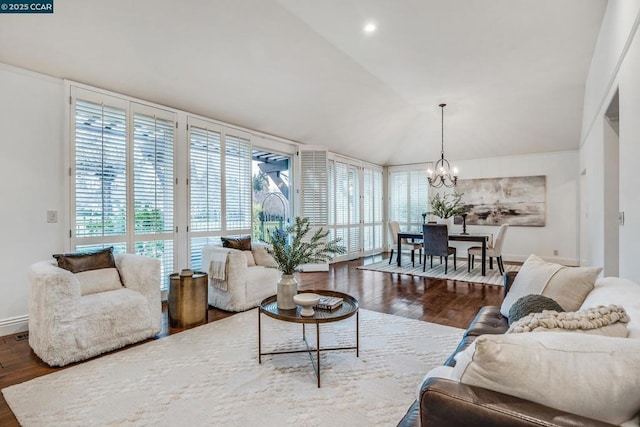 living room featuring dark wood-type flooring, vaulted ceiling, and an inviting chandelier