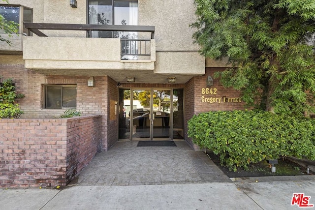 view of exterior entry with a balcony