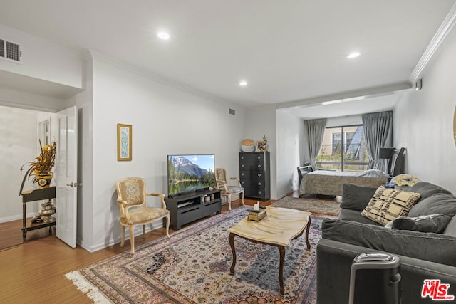 living room featuring crown molding and light hardwood / wood-style flooring