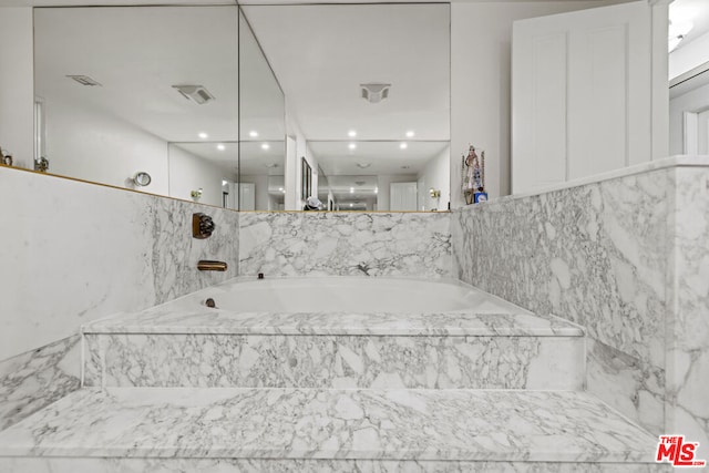 bathroom with a relaxing tiled tub