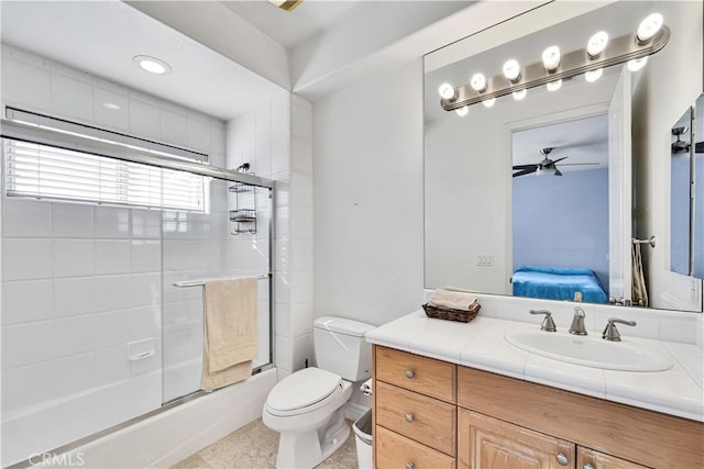 full bathroom featuring vanity, combined bath / shower with glass door, ceiling fan, and toilet