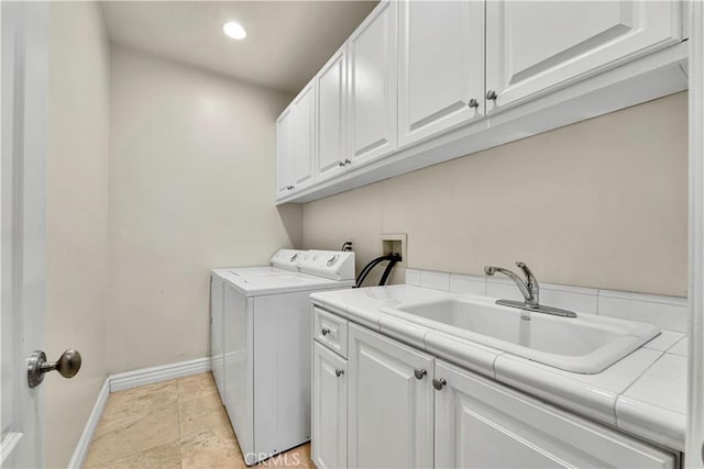 laundry area with cabinets, washer and dryer, and sink