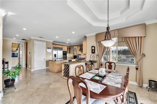 dining space with a raised ceiling and ornamental molding