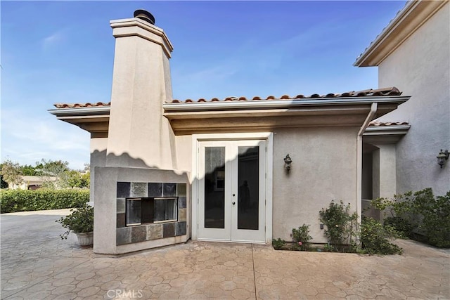 property entrance with a patio and french doors