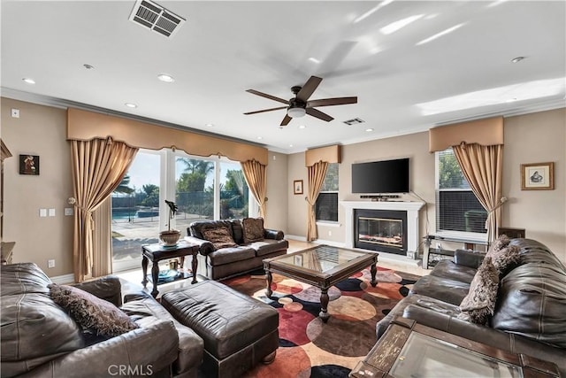 living room with crown molding and ceiling fan