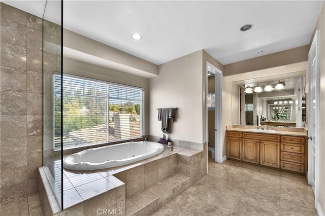 bathroom with vanity and tiled tub