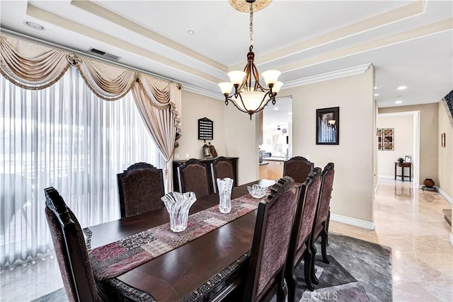 dining area featuring a raised ceiling, crown molding, and a chandelier