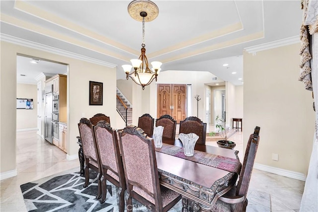 dining space with ornamental molding, a chandelier, and a tray ceiling