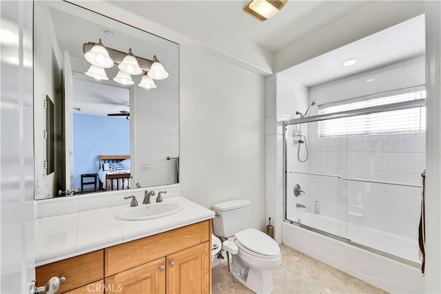 full bathroom with enclosed tub / shower combo, vanity, and toilet