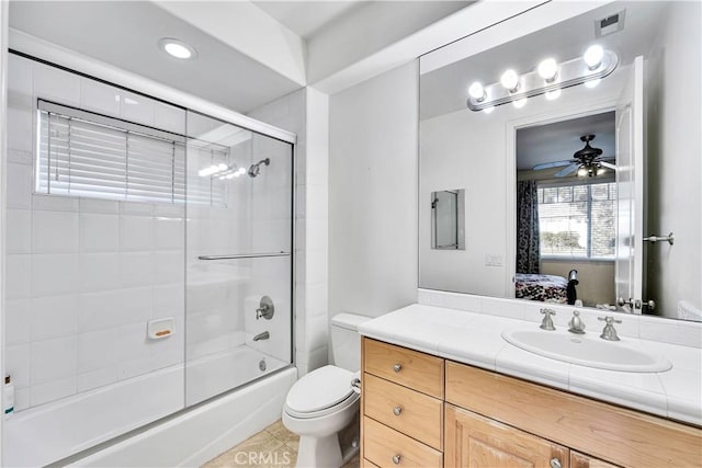 full bathroom featuring tile patterned floors, toilet, bath / shower combo with glass door, vanity, and ceiling fan