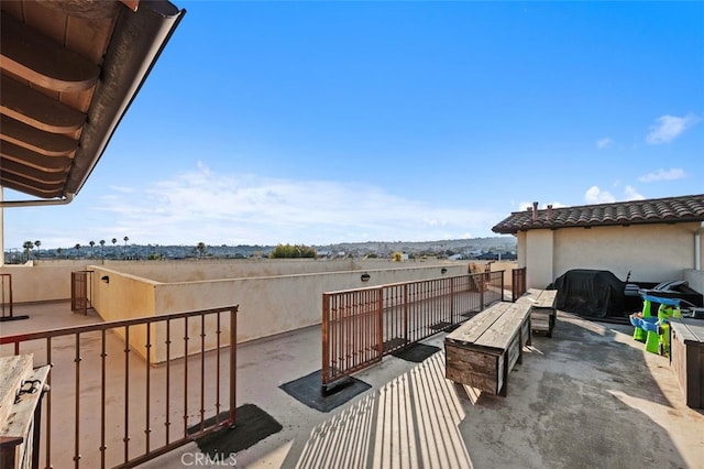 view of patio featuring a grill and a balcony