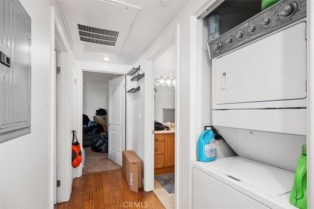 laundry area with stacked washer / dryer and light hardwood / wood-style floors