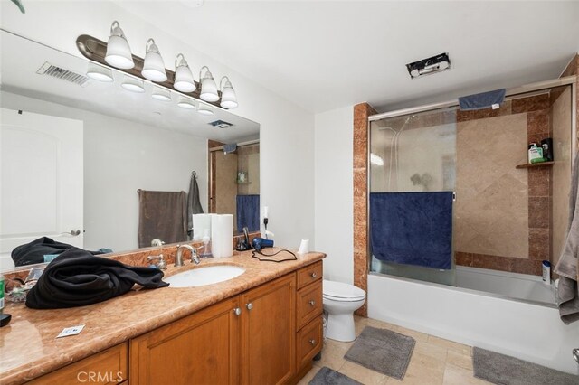 full bathroom with enclosed tub / shower combo, vanity, and toilet