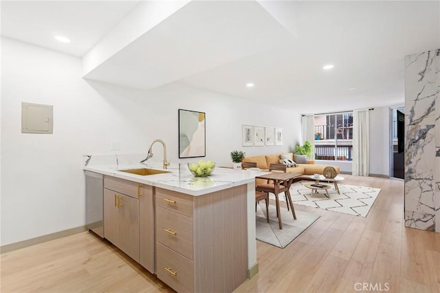 kitchen featuring sink, dishwasher, electric panel, kitchen peninsula, and light wood-type flooring