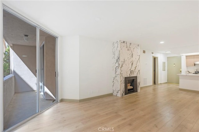 unfurnished living room featuring light hardwood / wood-style flooring and a premium fireplace