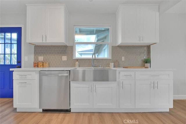 kitchen featuring white cabinetry, dishwasher, sink, decorative backsplash, and light hardwood / wood-style floors