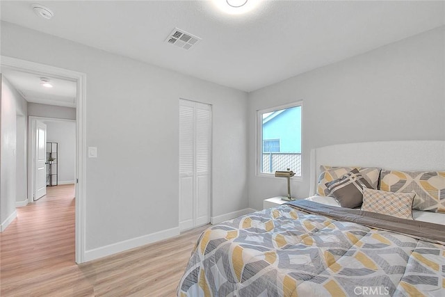 bedroom with light hardwood / wood-style flooring and a closet