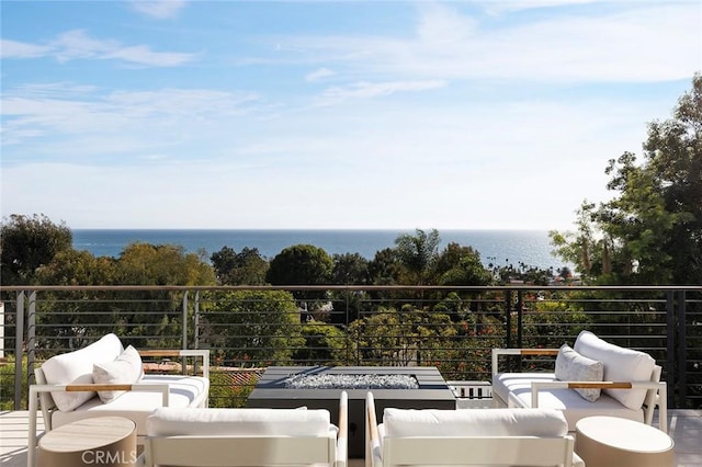 balcony with a water view and an outdoor living space with a fire pit