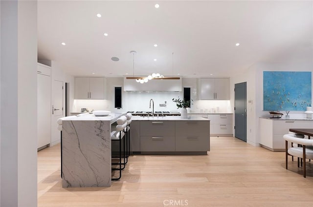 kitchen featuring pendant lighting, sink, a kitchen island, and gray cabinetry