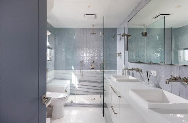 bathroom featuring walk in shower, vanity, toilet, and tile walls