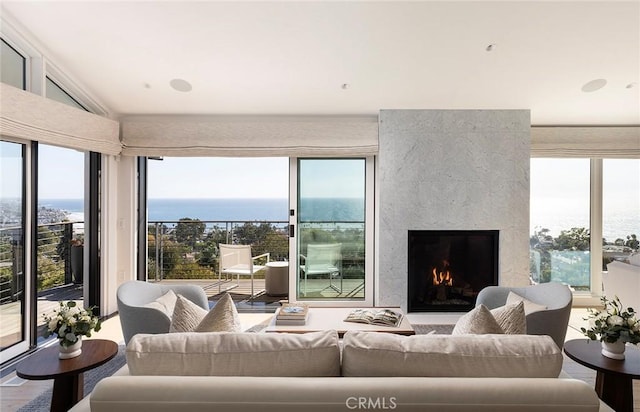 living room featuring a high end fireplace, wood-type flooring, and a water view