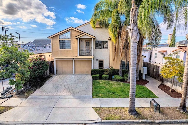 view of front of property featuring a garage, a balcony, and a front lawn