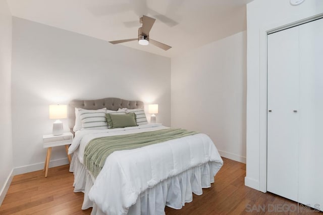 bedroom featuring hardwood / wood-style flooring, ceiling fan, and a closet