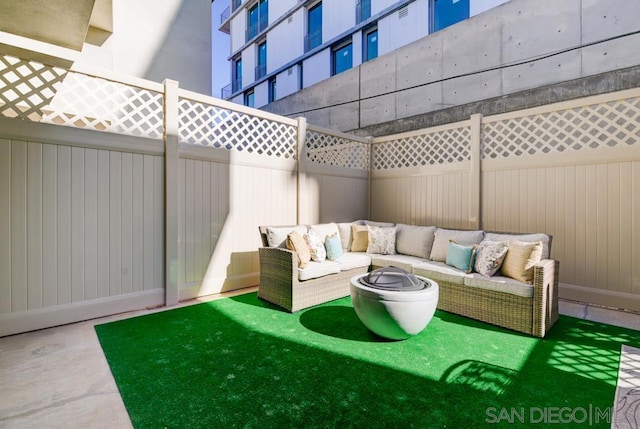 view of patio with an outdoor living space with a fire pit