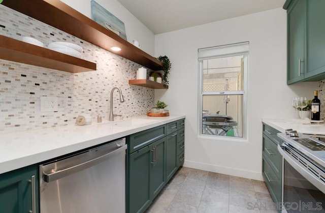 kitchen featuring tasteful backsplash, appliances with stainless steel finishes, sink, and green cabinetry