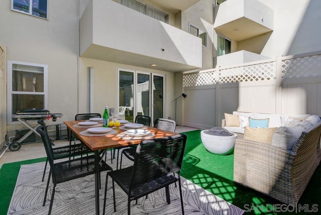 view of patio with an outdoor living space with a fire pit